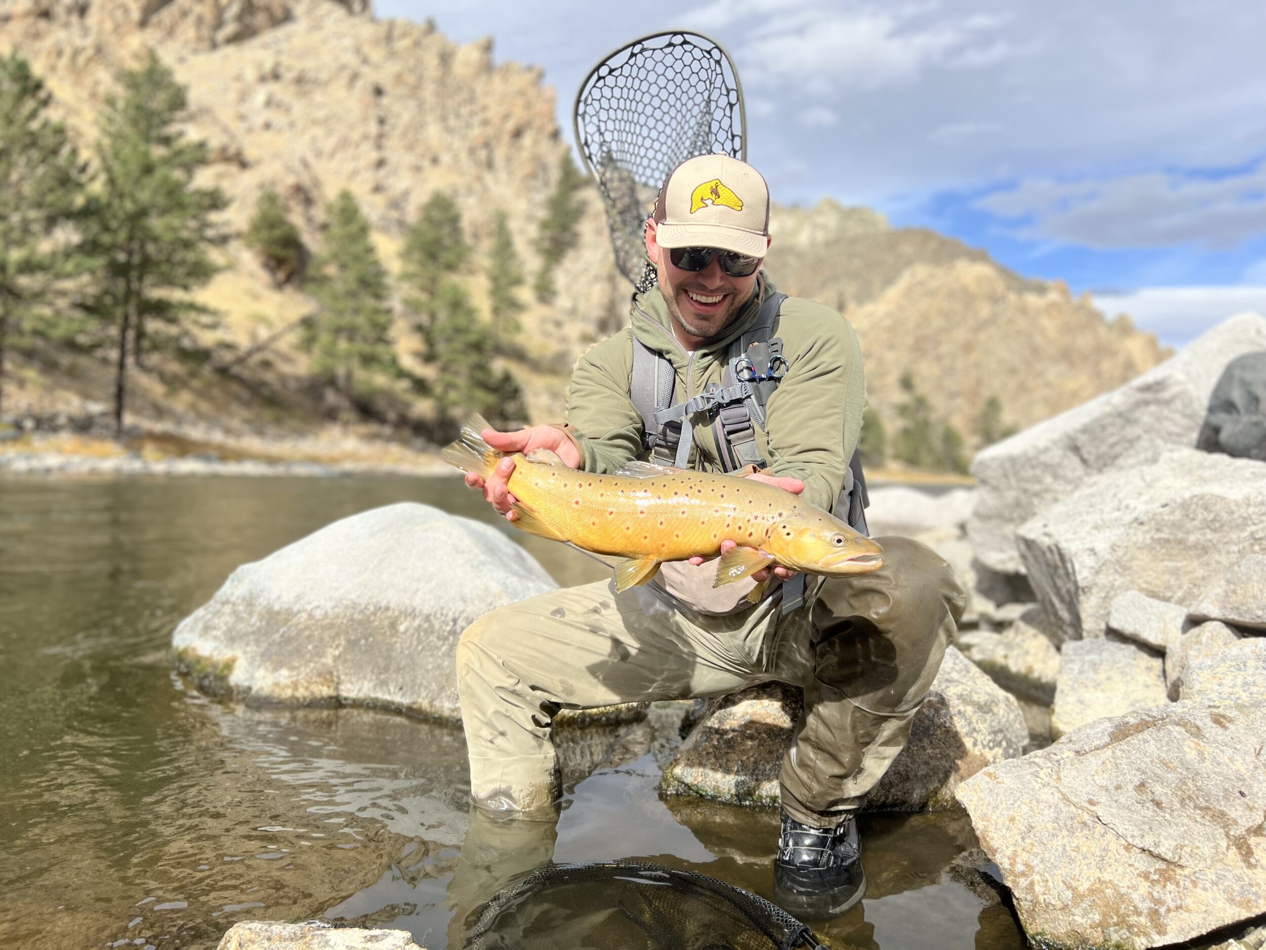 chase higgs holding a fish in a green jacket